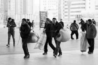 昨日，火车站广场，几名外出务工人员扛着行李踏上返乡路。YMG记者栾盛杰摄